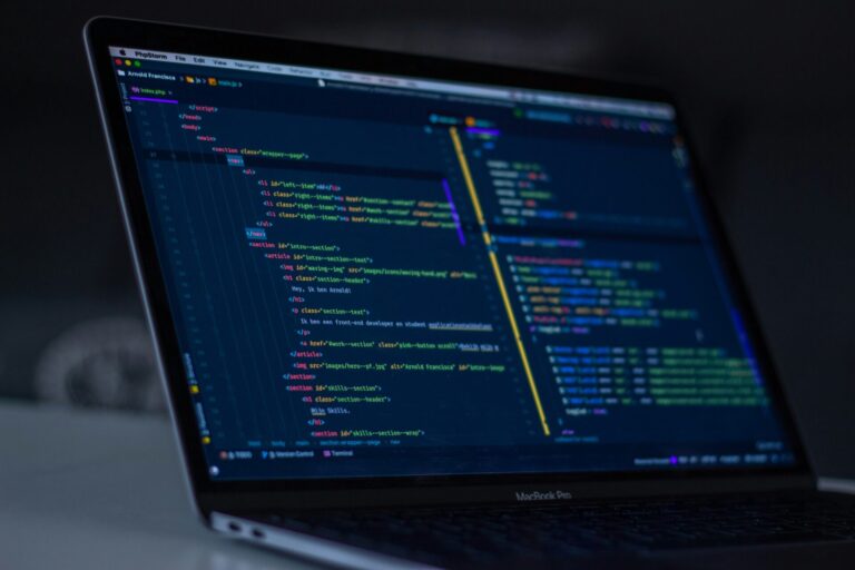 Persona programando en un portátil con notas de trabajo al lado